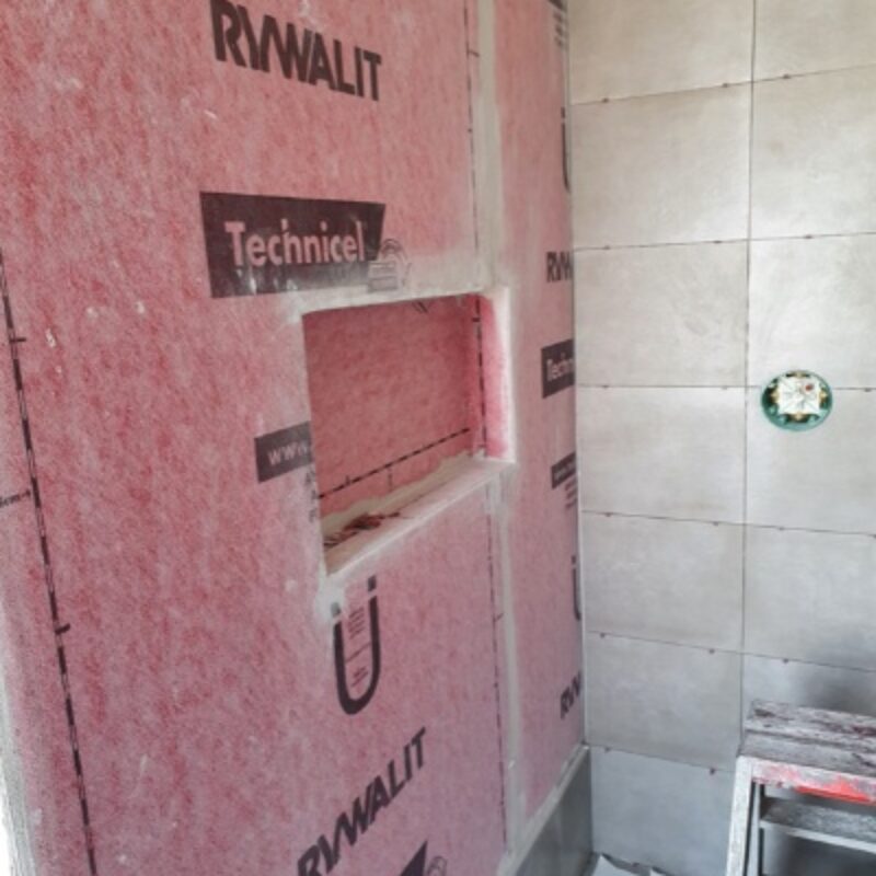 Plaatsen van waterdichting, douchegoot en keramische tegels in