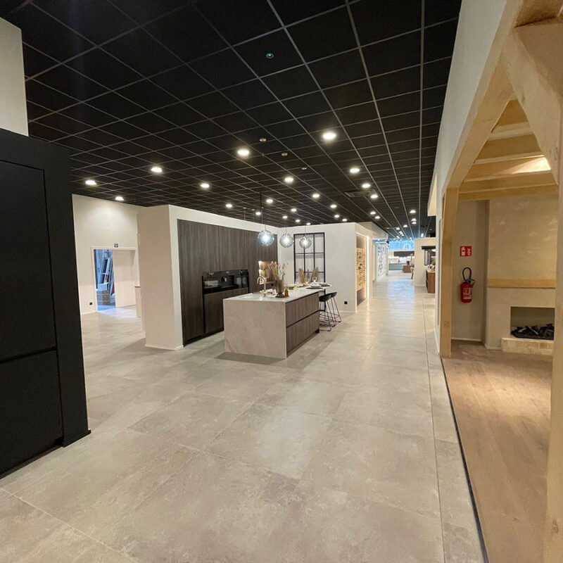 Keuken in een toonzaal volledig aangekleed met borden en stoelen, geplaatst met tegellijm van hoge kleefsterkte, onkoppelingsmat, snelhardende voegmortel en afgewerkt met silicone voor keramiek.